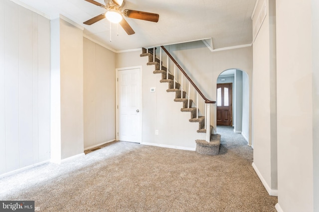 interior space featuring ceiling fan, carpet floors, and ornamental molding