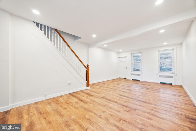 unfurnished living room with light hardwood / wood-style floors and radiator