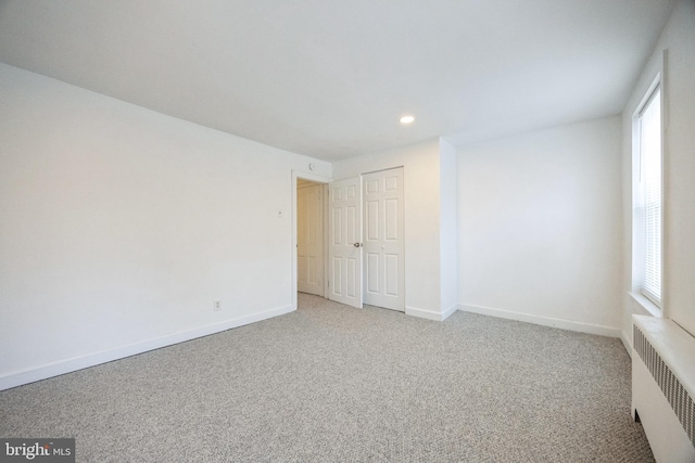 carpeted spare room with radiator heating unit