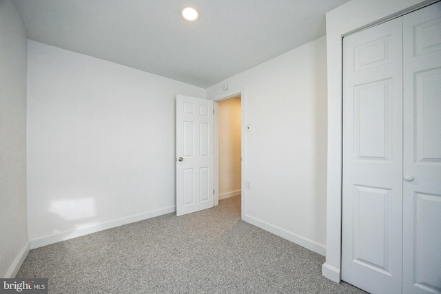 unfurnished bedroom featuring carpet and a closet