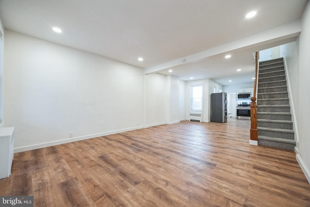 interior space with radiator heating unit, light hardwood / wood-style flooring, and stainless steel refrigerator