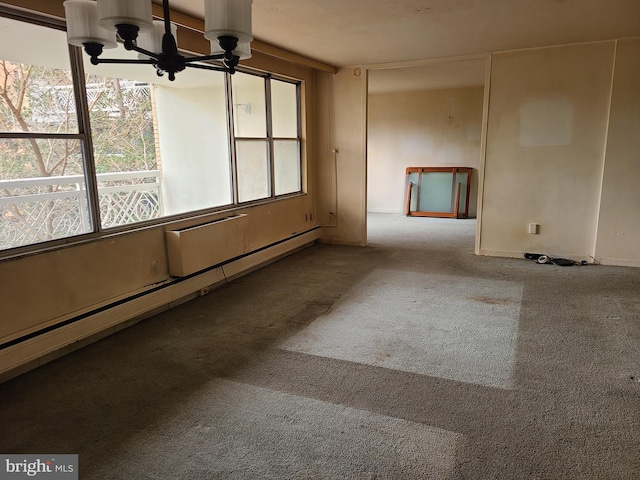 spare room with a baseboard radiator, a chandelier, and carpet flooring