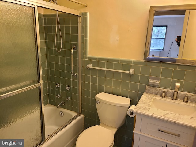 full bathroom featuring toilet, vanity, tile walls, and enclosed tub / shower combo