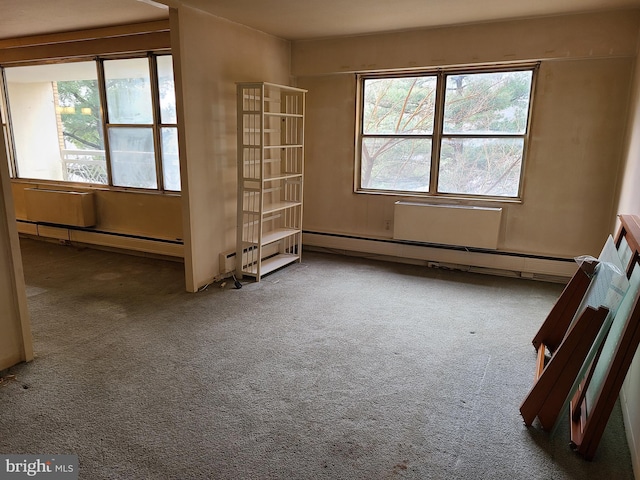 unfurnished room featuring carpet floors and a baseboard radiator