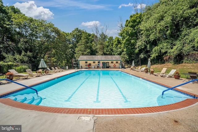 view of pool with an outbuilding and a patio