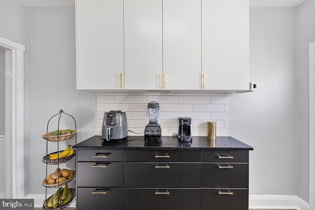 bar featuring decorative backsplash and white cabinetry