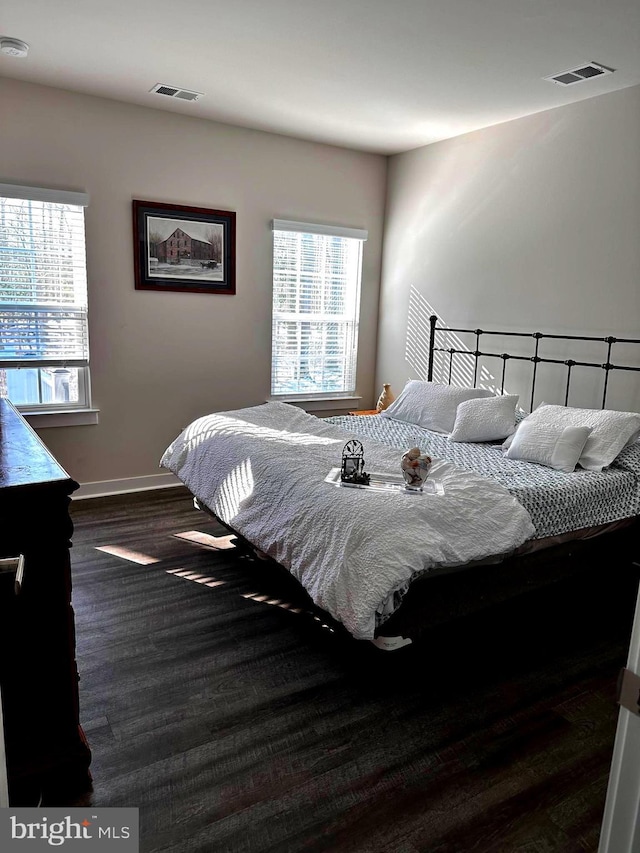 bedroom with dark hardwood / wood-style floors