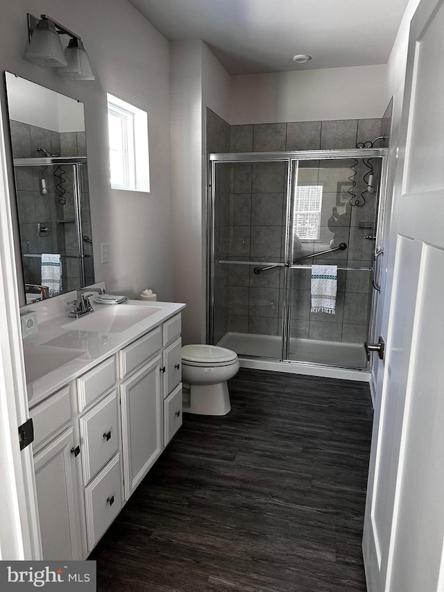 bathroom featuring vanity, hardwood / wood-style floors, toilet, and walk in shower