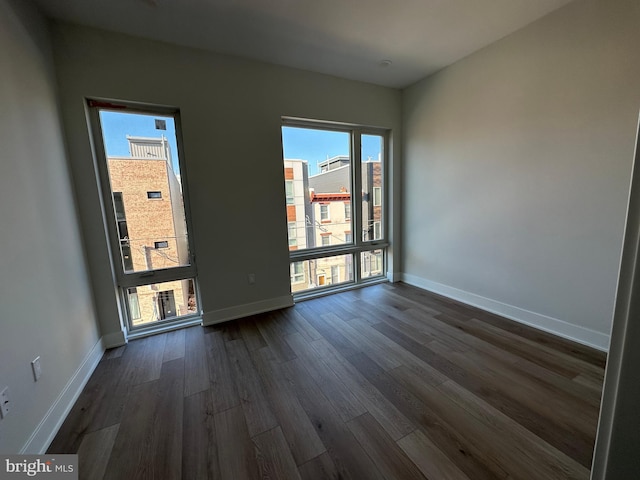 empty room featuring dark hardwood / wood-style floors and a healthy amount of sunlight