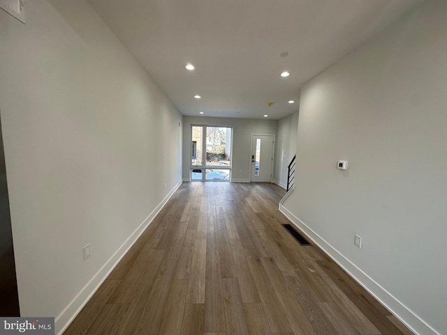 hallway with hardwood / wood-style flooring