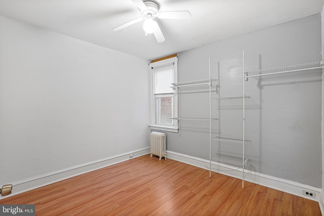 spare room featuring hardwood / wood-style flooring, ceiling fan, and radiator