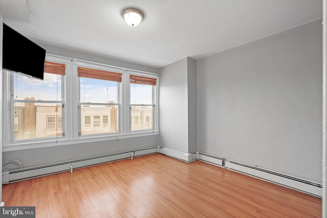 spare room featuring a baseboard radiator and light hardwood / wood-style flooring