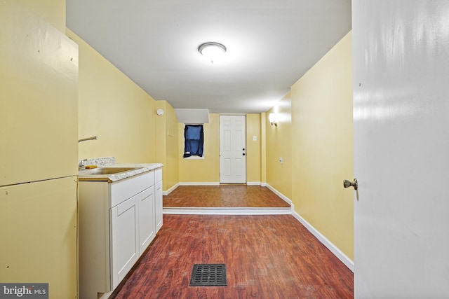 corridor featuring dark wood-type flooring and sink