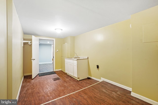 laundry area featuring hardwood / wood-style floors and sink