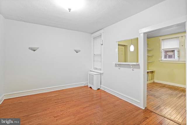 unfurnished room featuring hardwood / wood-style floors and a textured ceiling