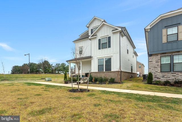 view of front of property featuring central air condition unit and a front lawn