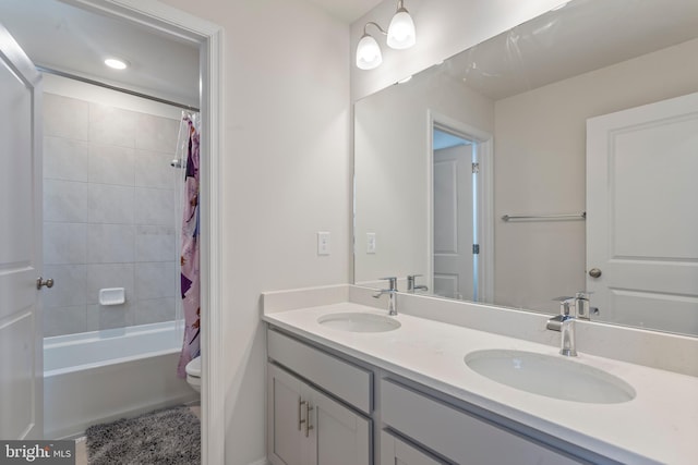 full bathroom featuring shower / bath combo with shower curtain, vanity, and toilet