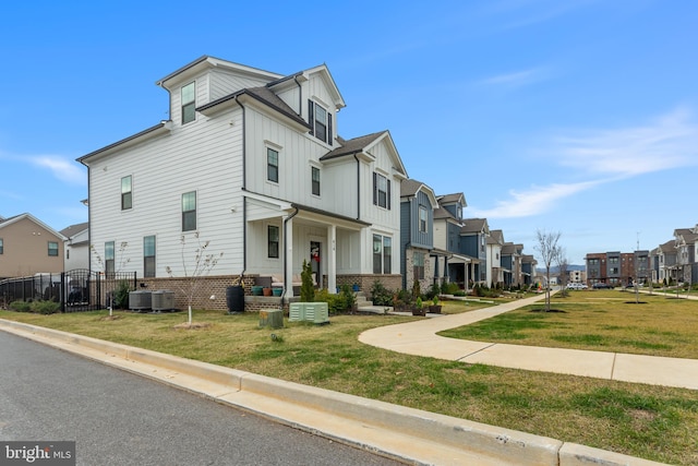 view of front of property with a front lawn and central air condition unit