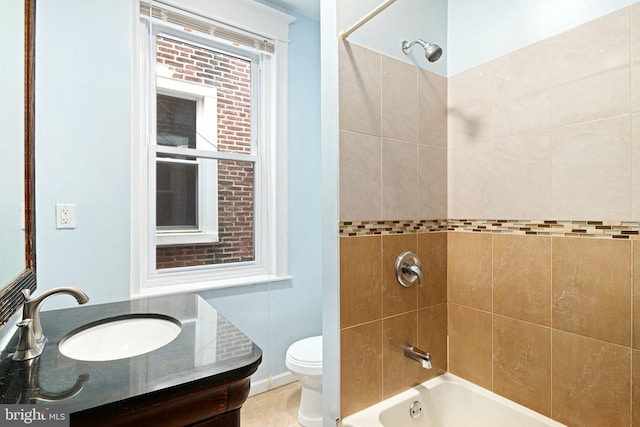 full bathroom featuring vanity, toilet, and tiled shower / bath