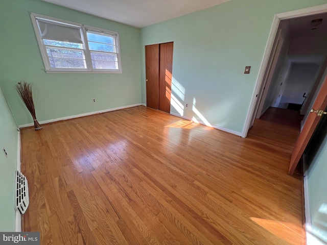 unfurnished bedroom with a closet and light hardwood / wood-style flooring