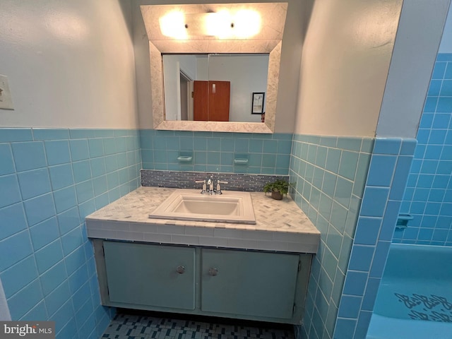 bathroom featuring tile patterned flooring, vanity, and tile walls