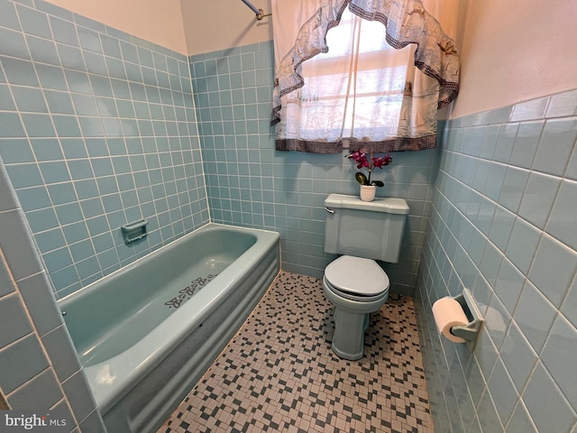 bathroom with washtub / shower combination, tile walls, and toilet