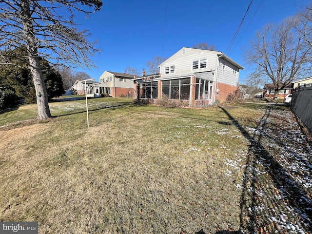 back of house featuring a yard and a sunroom