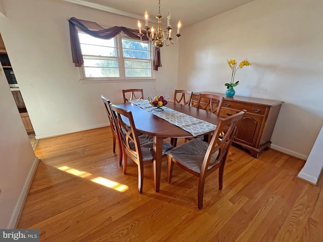 dining space featuring light hardwood / wood-style flooring and a notable chandelier