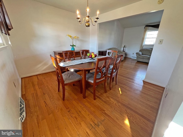 dining space with a chandelier, light hardwood / wood-style floors, and a baseboard radiator