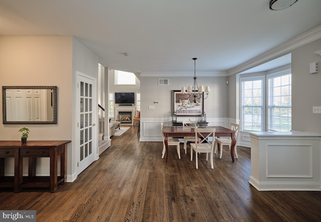 dining space featuring dark hardwood / wood-style flooring, a chandelier, and ornamental molding