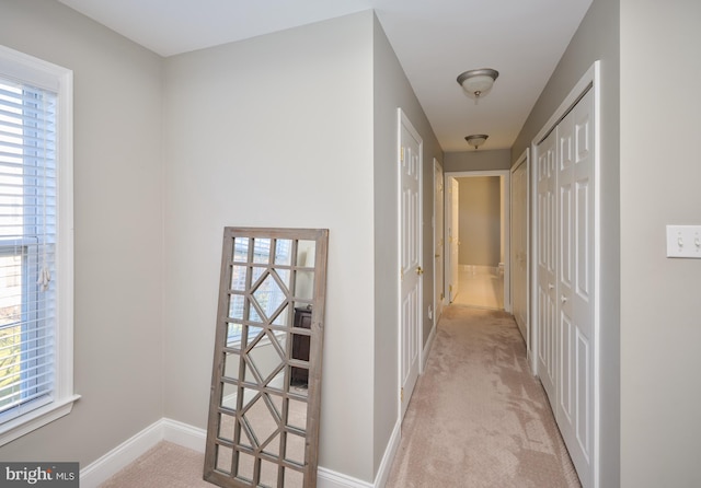 hall with light colored carpet