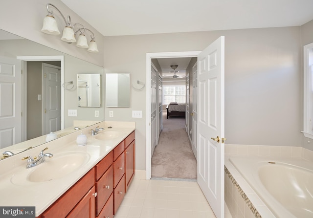 bathroom featuring vanity and a relaxing tiled tub