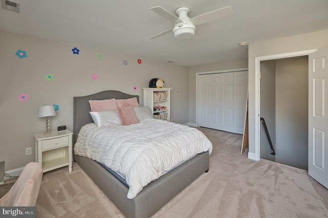 bedroom with ceiling fan, light colored carpet, and a closet