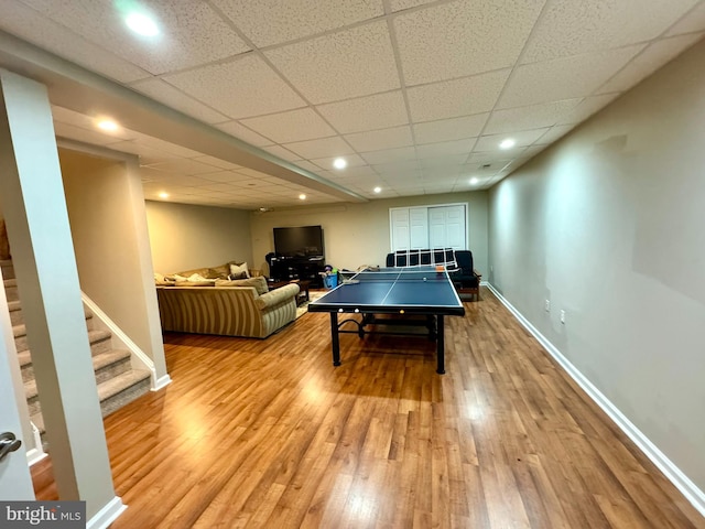 game room with hardwood / wood-style flooring and a drop ceiling