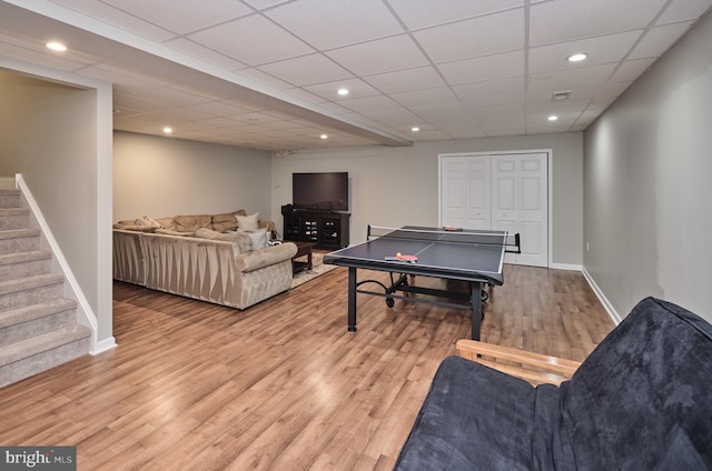 playroom with a paneled ceiling and light wood-type flooring