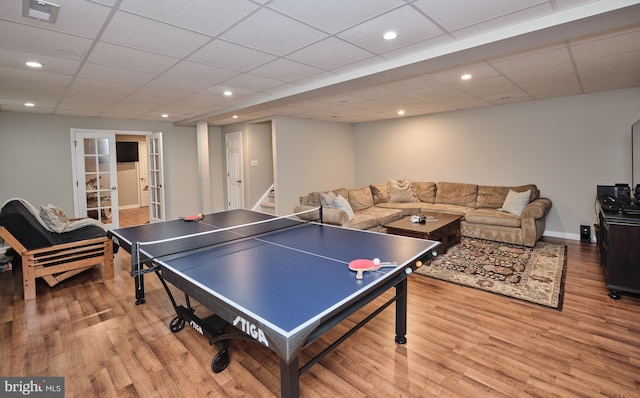 recreation room featuring french doors, a paneled ceiling, and light hardwood / wood-style floors