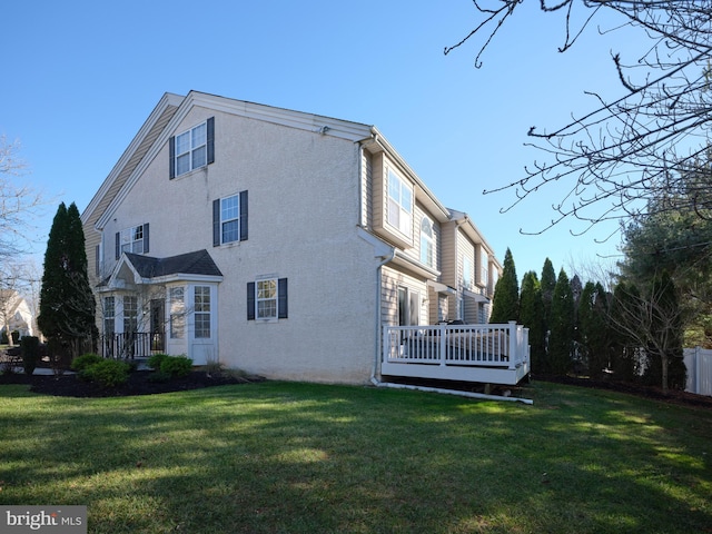 rear view of property with a yard and a wooden deck