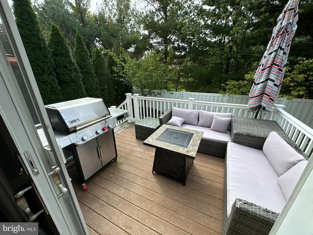 wooden deck featuring a grill and an outdoor living space with a fire pit