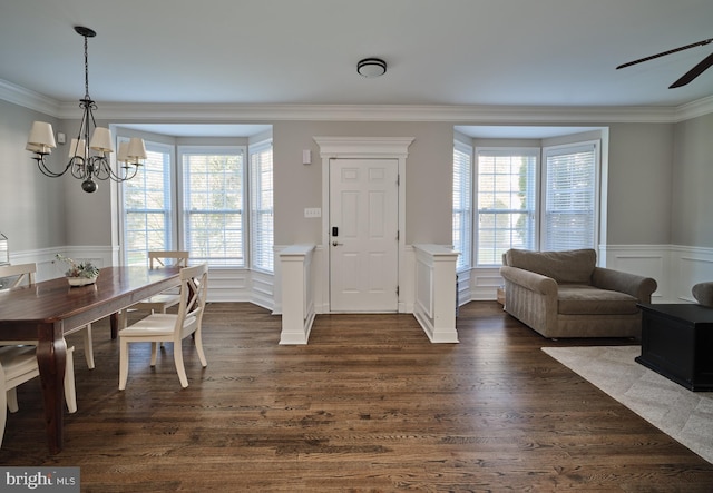 entrance foyer featuring dark hardwood / wood-style floors, a wealth of natural light, and ornamental molding