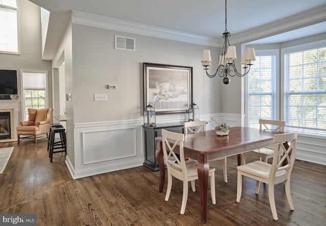 dining area with dark hardwood / wood-style flooring, crown molding, and a chandelier