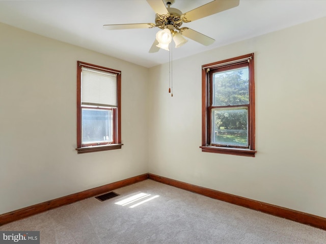 carpeted spare room featuring ceiling fan