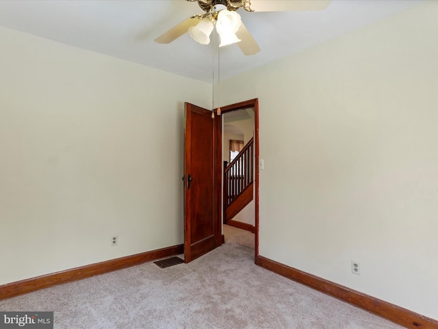 empty room with ceiling fan and light colored carpet