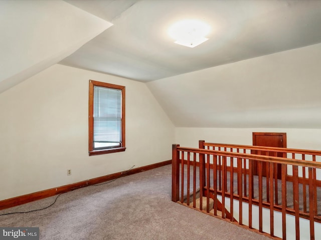 additional living space featuring carpet flooring and lofted ceiling