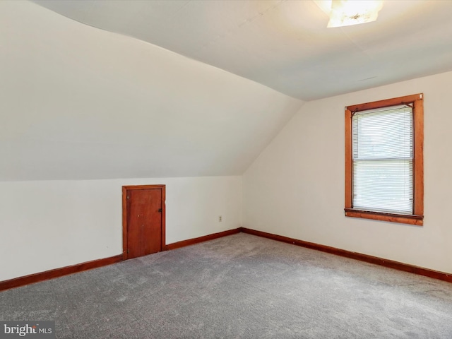 bonus room with lofted ceiling and carpet floors