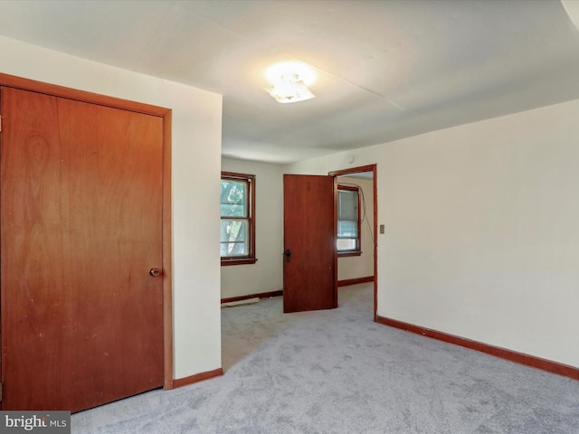 unfurnished bedroom with light carpet and a closet