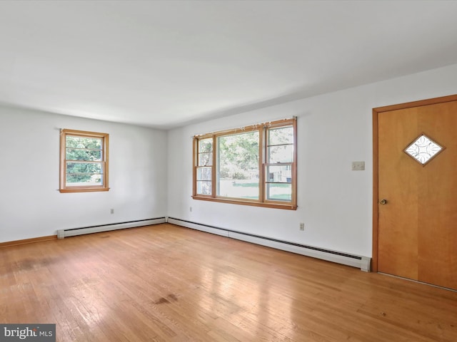 foyer featuring a healthy amount of sunlight, a baseboard heating unit, and light hardwood / wood-style flooring