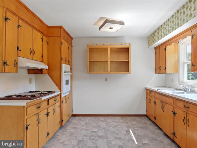 kitchen with white oven, sink, and stainless steel gas cooktop