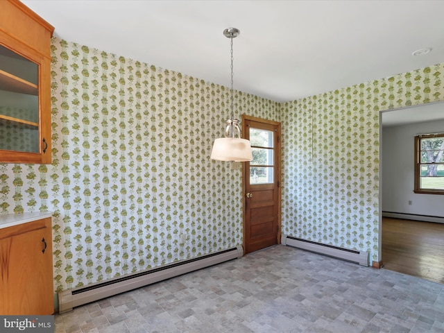 unfurnished dining area featuring light hardwood / wood-style flooring and a baseboard heating unit