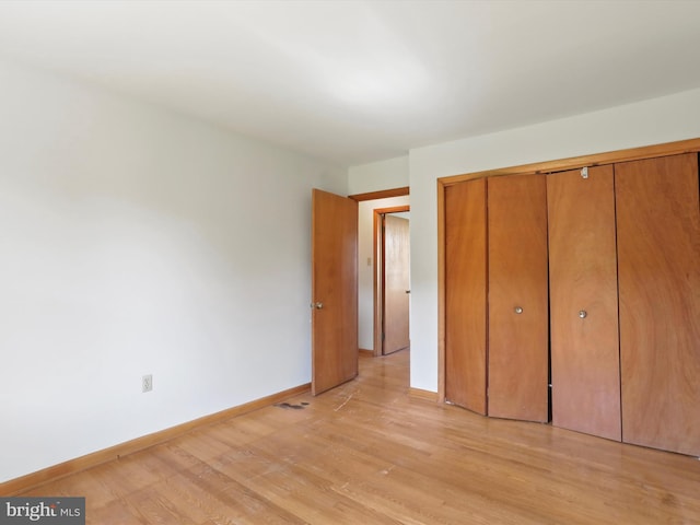 unfurnished bedroom featuring a closet and light hardwood / wood-style flooring