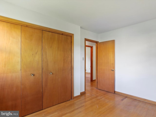 unfurnished bedroom featuring a closet and light hardwood / wood-style flooring